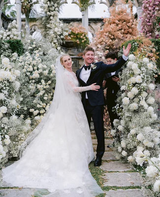 Bride and groom wave to the crowd after being announced as man and wife. Surrounded by floral instillation by Tulipina Designs photo taken by Jose Villa