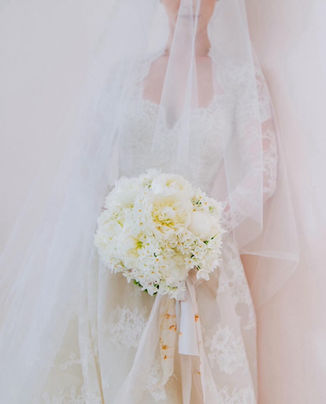 Bride with veil covering her face showcasing her beautiful florals by Tulipina Designs 