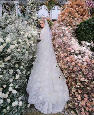 Bridal portrait after ceremony looking over her shoulder with veil cascading down surrounded by florals by Tulipina Designs 