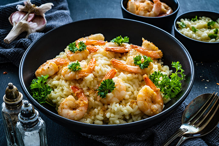 Plat fait maison d'un risotto à la bisque de homard et aux crevettes