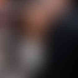 A couple walks hand-in-hand on a snowy Chicago Riverwalk path, surrounded by leafless trees and buildings. They appear happy and relaxed. Chicagoland Wedding Photographer, Chicagoland Proposal Photographer, Chicagoland Engagement Photographer, Geneva Wedding Photographer, Chicago Riverwalk engagement session, snowy chicago engagement session, winter chicago engagement session