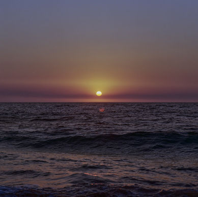 Sun setting over a flat ocean horizon