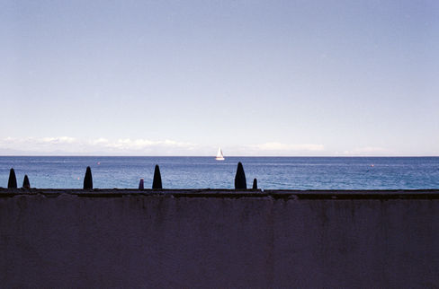 Single white sailboat on the blue horizon.