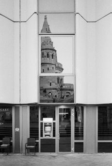 Historical architecture reflected in modern glass building facade.