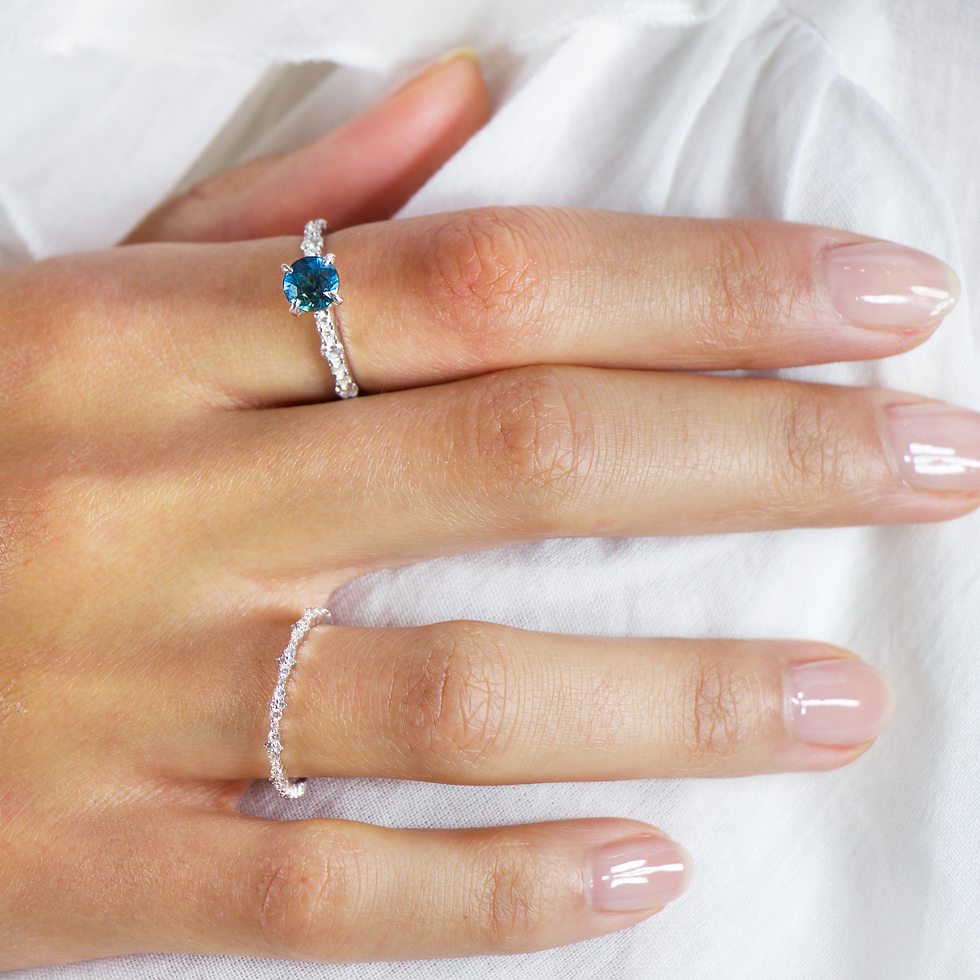 Hand model wearing a 18K White Gold Diamond Wedding Band in the ring finger with a blue sapphire ring in the index finger