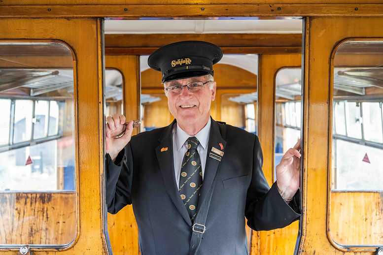 Travelling Ticket Inspector at the doorway of a compartment