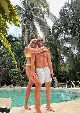 Engaged couple in a tropical setting by a pool who are planning their destination wedding at Dreams Playa Mujeres in Mexico.