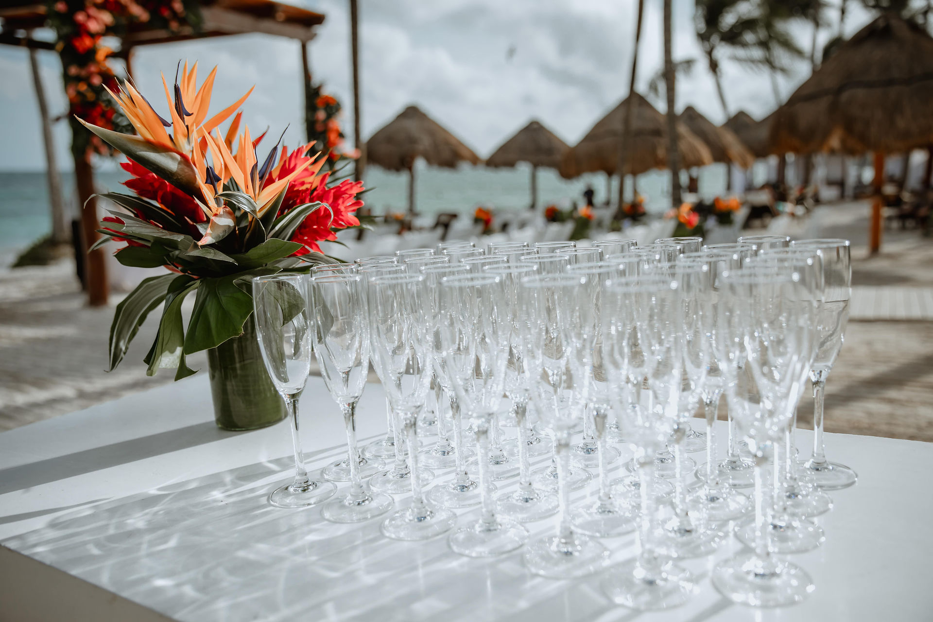 Champagne glasses and tropical flowers at all inclusive wedding at Secrets Akumal in Mexico planned by travel agent for destination weddings, EverAfter Travel.
