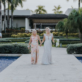 Bride walking down the aisle with her mom at the Fountain Gazebo wedding venue at Dreams Onyx.