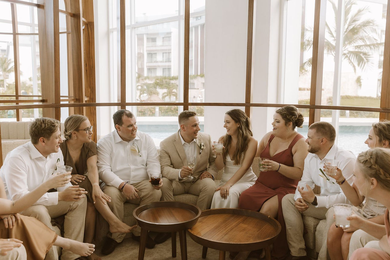 Wedding party having cocktails and chatting at the lower lobby bar at Majestic Elegance Costa Mujeres.
