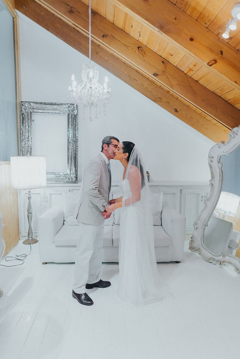 Father of the bride kissing his daughter on the cheek.