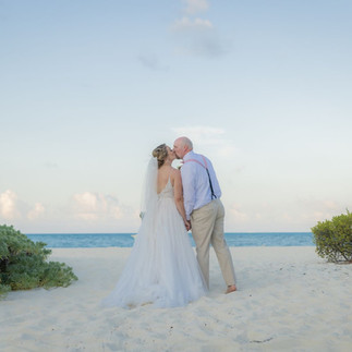 Bride and groom kissing on the beach after their ceremony at the Beach Gazebo at Dreams Playa Mujeres.