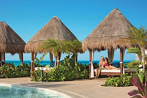 Couple relaxing on balinese beds at Dreams Playa Mujeres wedding resort in Mexico.