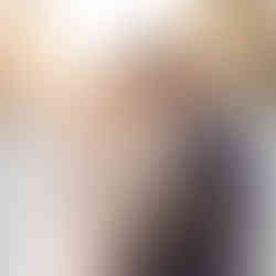 Tropical wedding couple embracing on the beach with palm trees behind them.