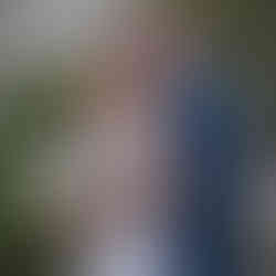 Bride and groom smiling and embracing outdoors at their destination wedding in Mexico, surrounded by tropical greenery and modern resort buildings.