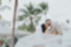 Destination wedding bride and groom kissing with swirling veil.