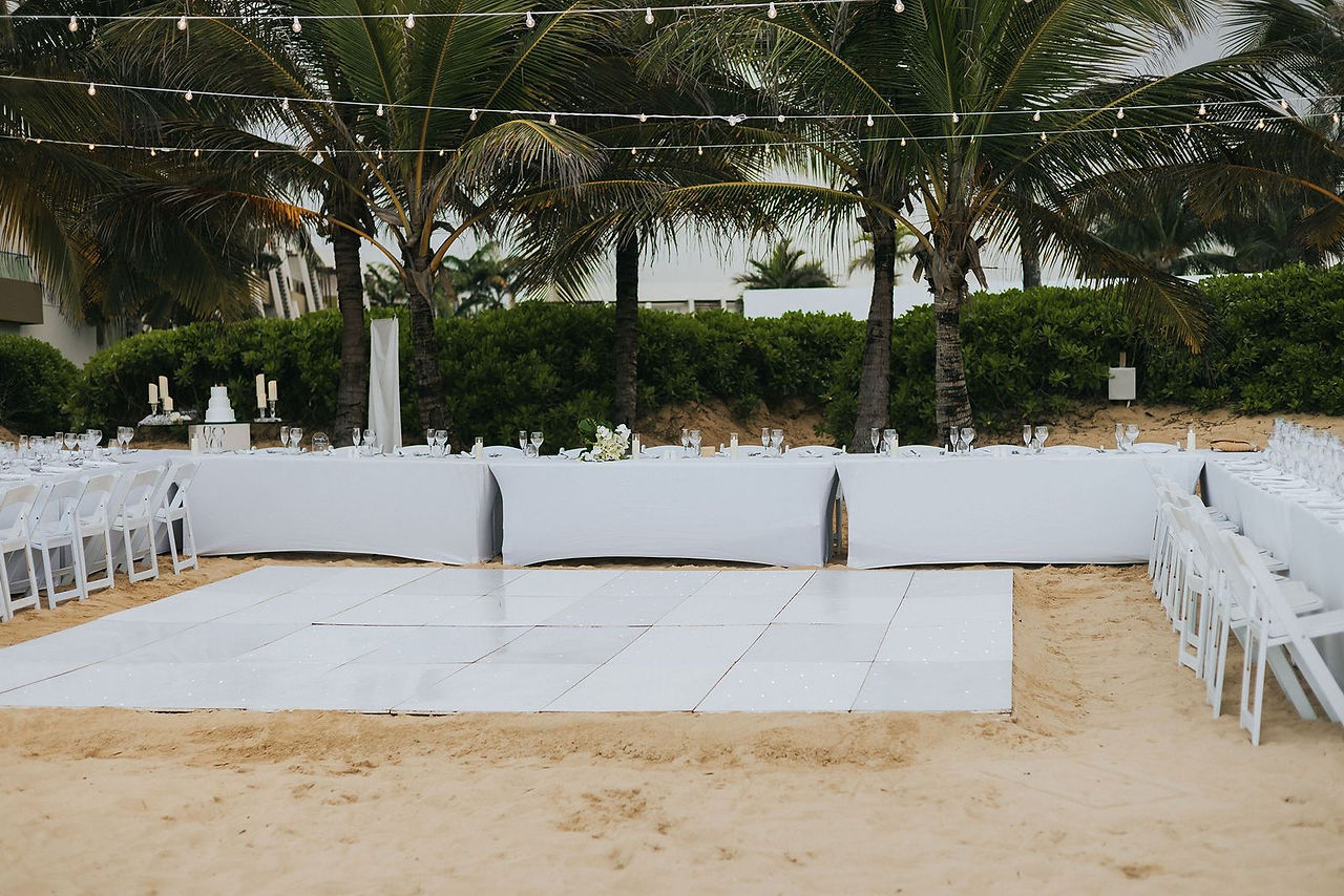 Head table and white dance floor at beach reception in Punta Cana.