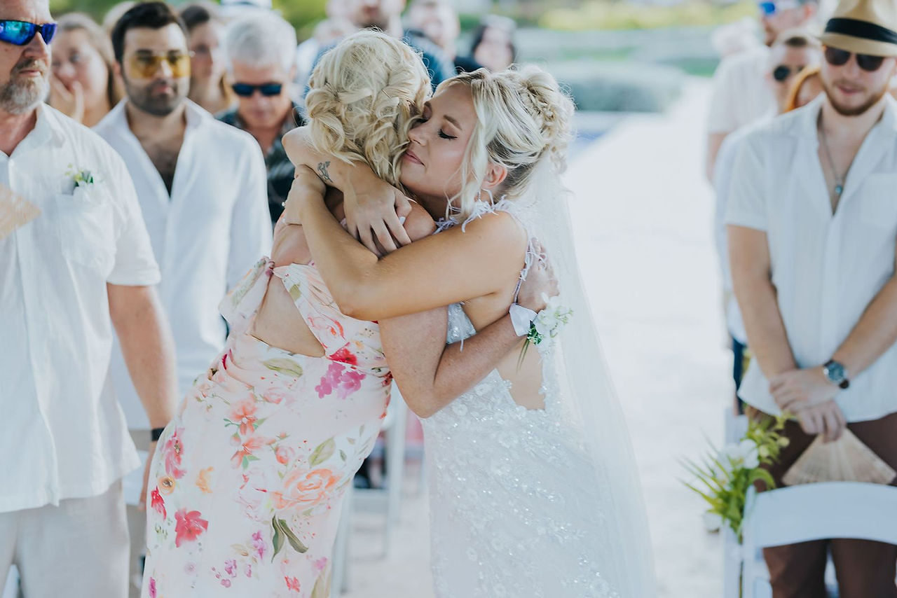 Bride hugging her mom at her wedding ceremony.