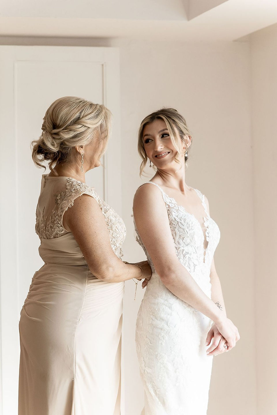 Mother of the bride helping with wedding dress.
