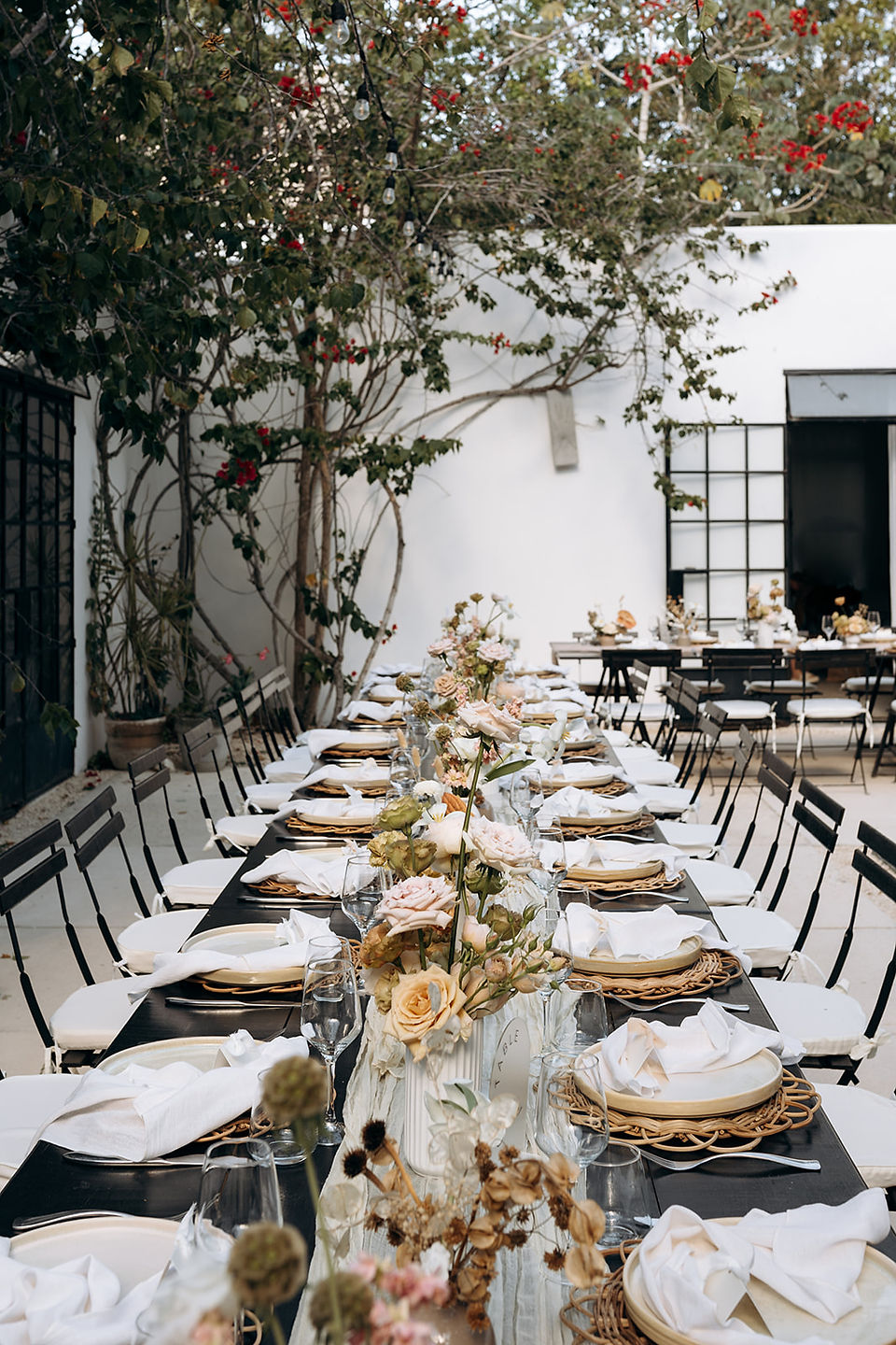 Mediterranean style wedding reception withl boho decor on poolside terrace venue at Kima Tulum in Mexico.
