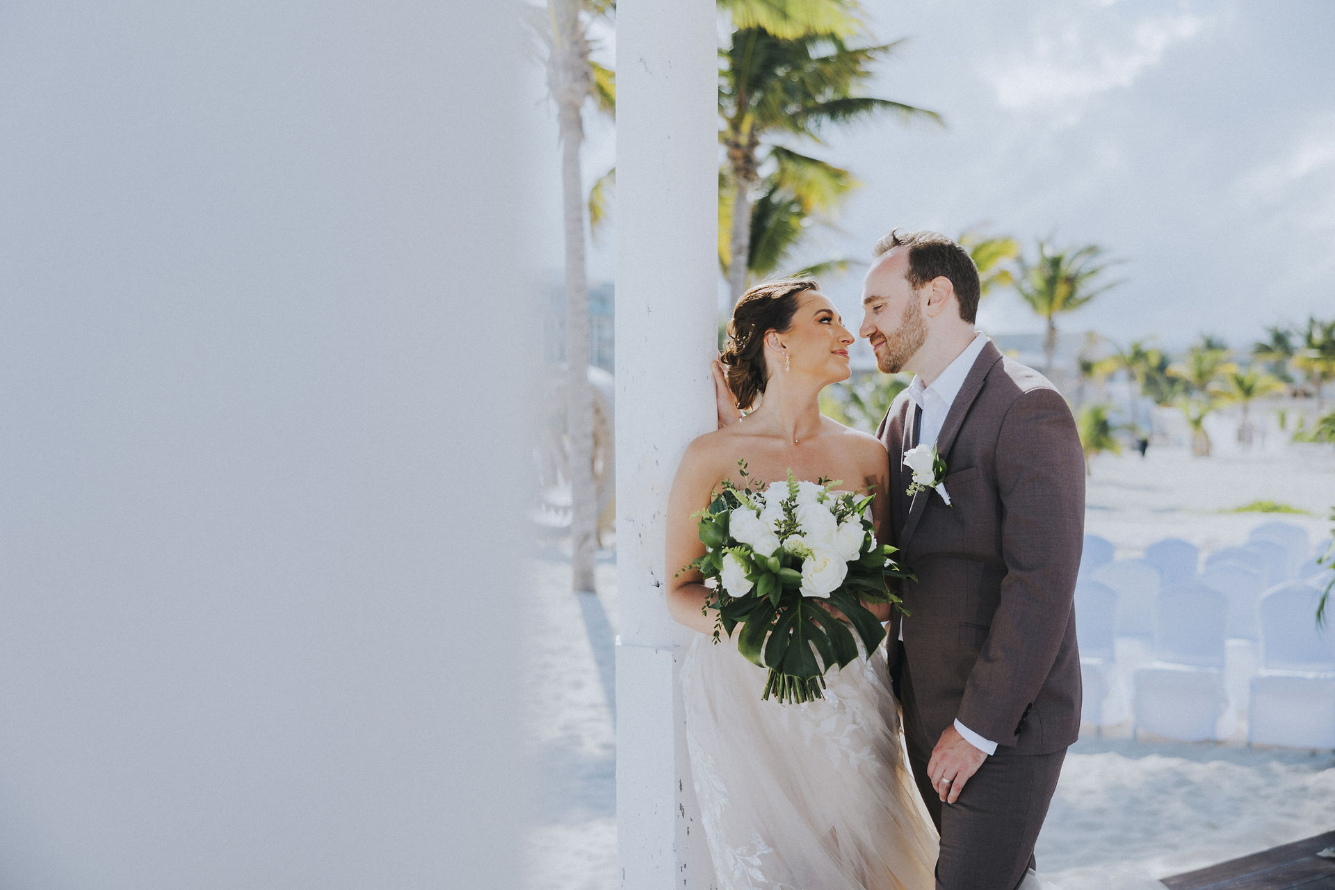 Bride and groom looking into each other's eyes at their Majestic Elegance Costa Mujeres wedding resort in Mexico planned by travel agent for destination weddings, EverAfter Travel.