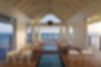Overwater chapel at Sandals South Coast resort in Jamaica with white chairs and a glass floor aisle.