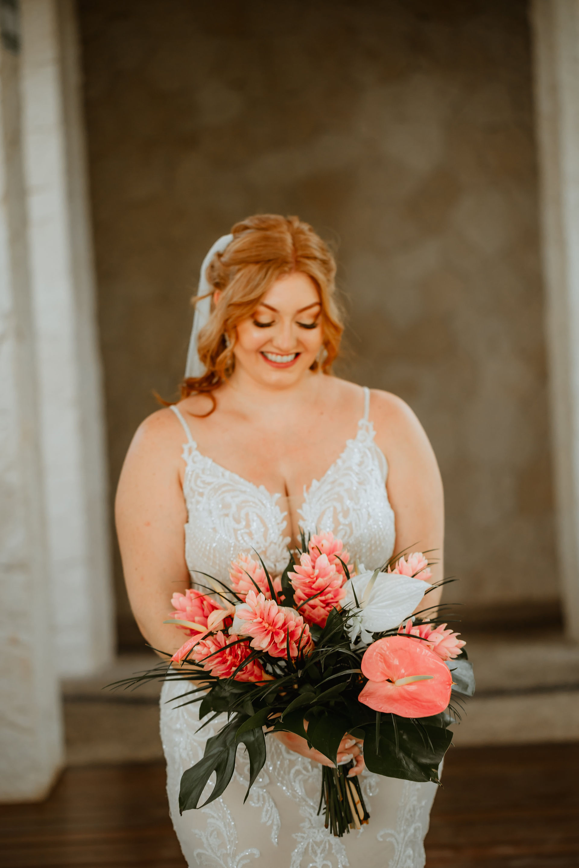 Bride holding tropical bouquet at her all inclusive wedding at Secrets Akumal in Mexico planned by travel agent for destination weddings, EverAfter Travel.