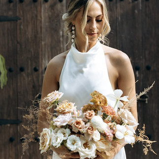 Bride looking at her boho wedding bouquet in Tulum, Mexico.