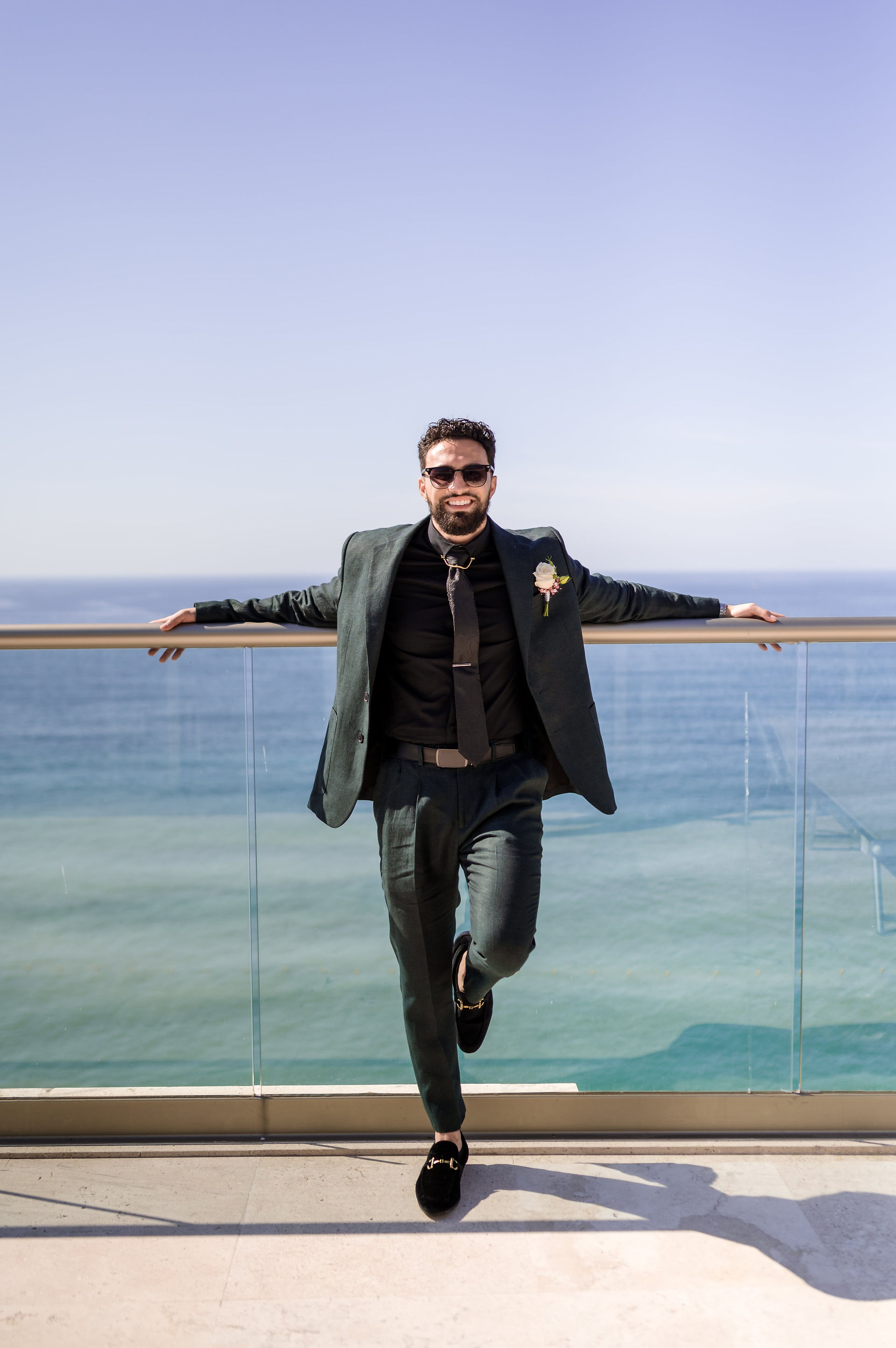 Groom on balcony with ocean backdrop at all inclusive wedding at Hyatt Ziva Puerto Vallarta in Mexico.