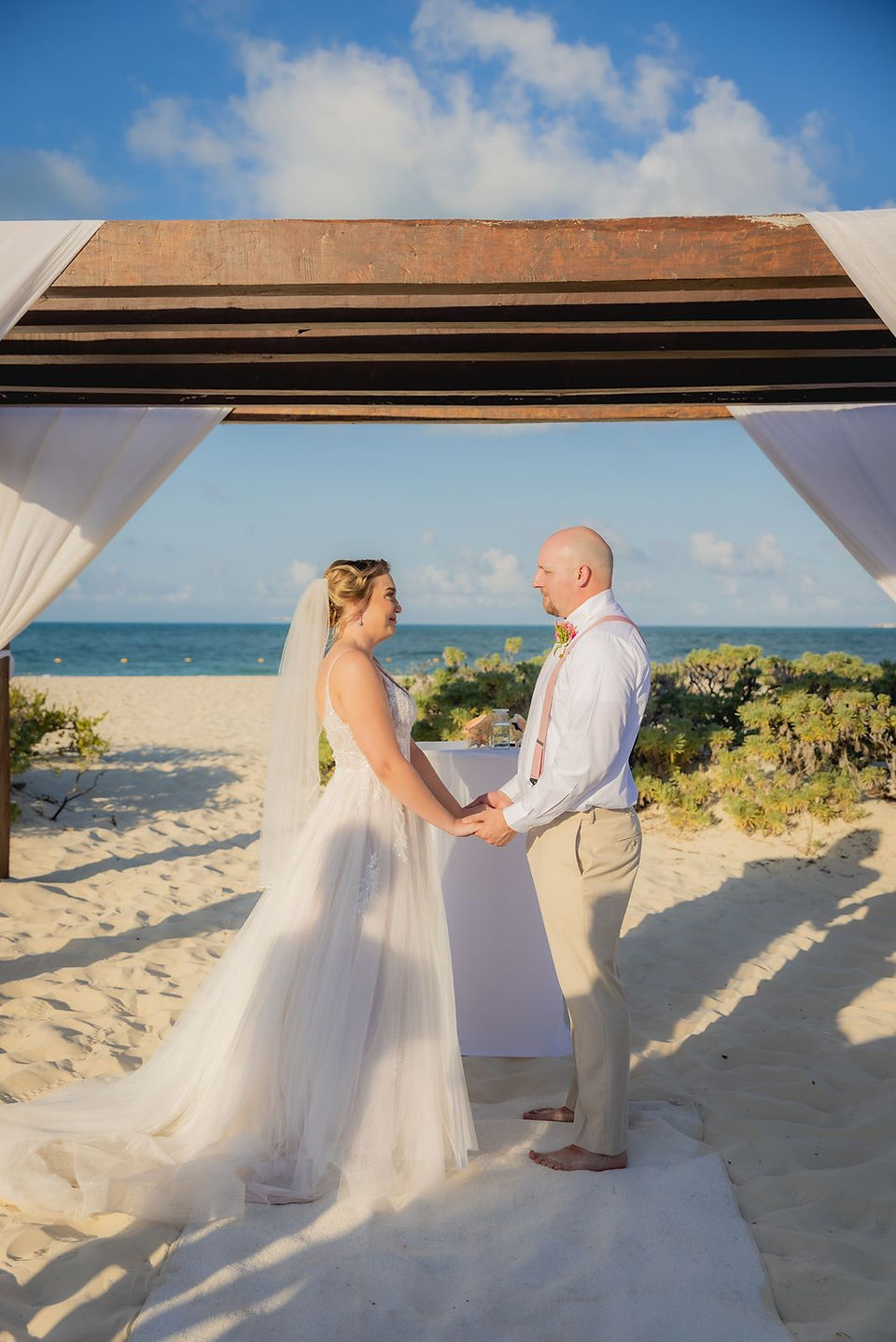 Beach Gazebo wedding ceremony with bride and groom holding hands at Dreams Playa Mujeres.