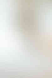 Bride looking at her white tropical bouquet by a window at her Dreams Royal Beach wedding in the Dominican Republic.