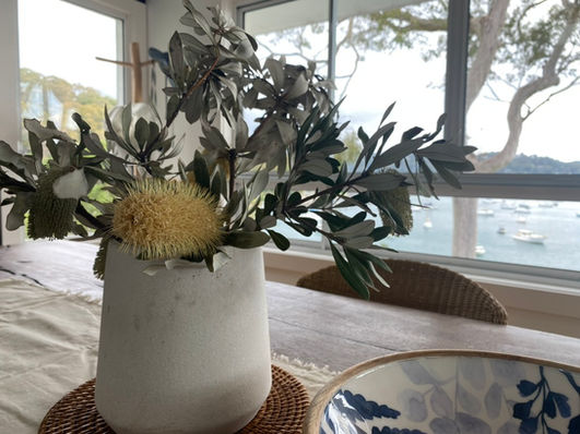 Inviting dining area with carefully styled accessories and repositioned coastal artwork, enhancing the home’s serene aesthetic.