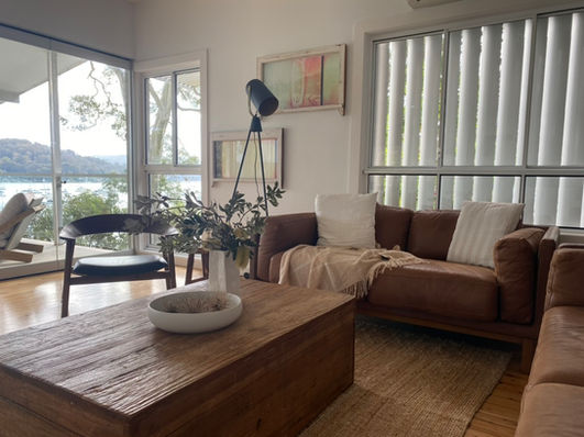 Airy living space with thoughtfully arranged seating, featuring existing furniture styled for relaxed coastal living.