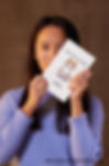 Woman holding a notebook with cat illustration, Mindful Journals, text. 