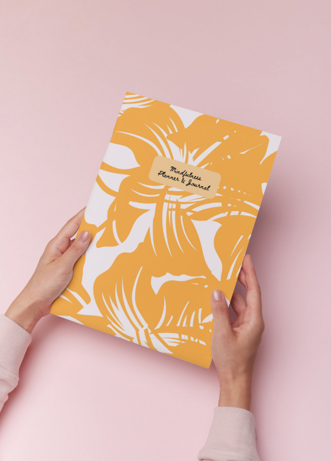 Hands holding floral journal with text that reads Mindful Planner & Journal. Mindful Journals
