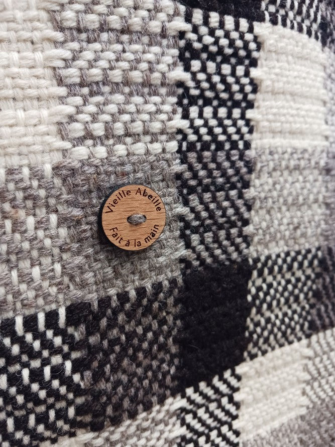 Une écharpe tissée main en pure laine française, non teinte ni traitée. Blanc, gris et marron foncé.