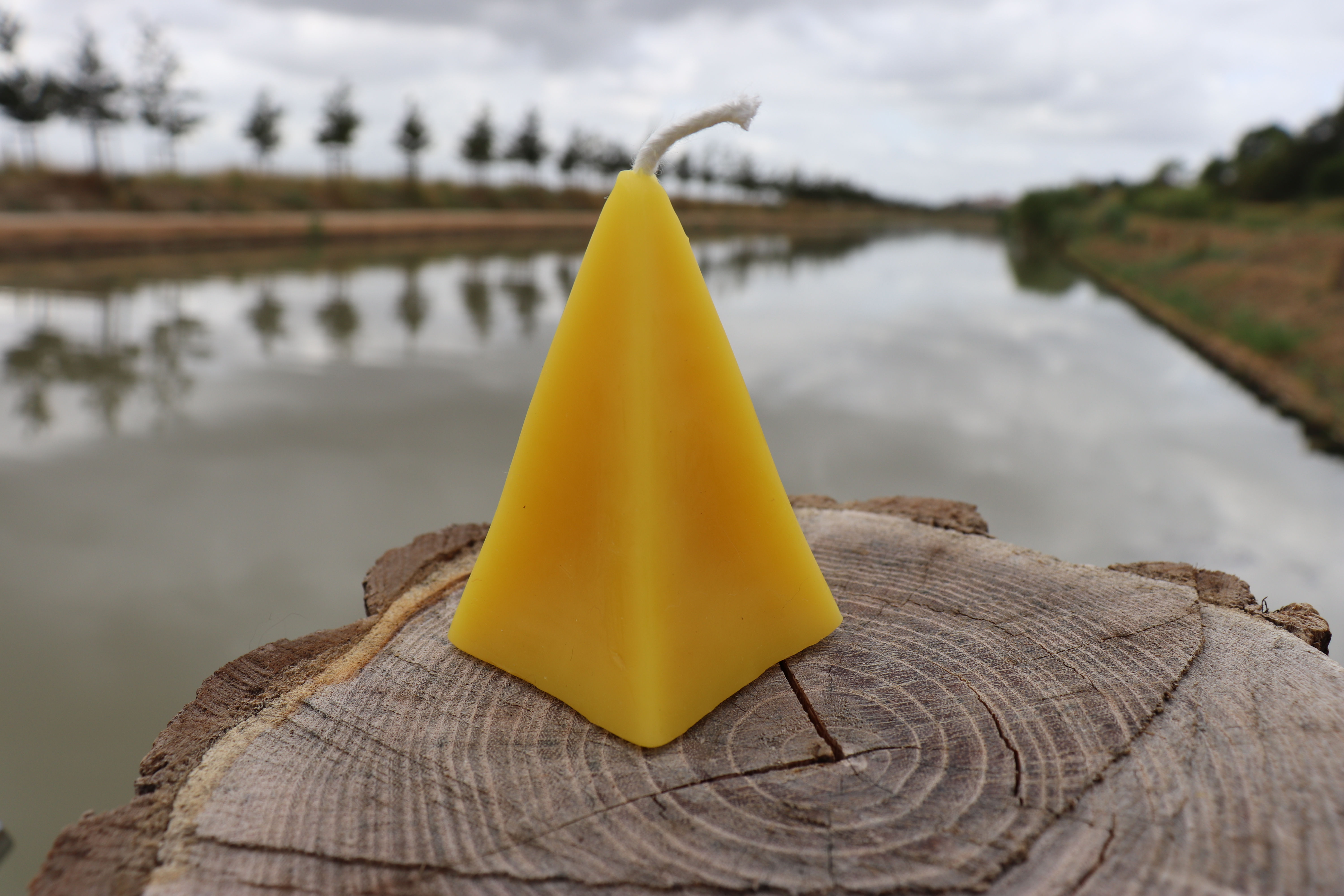 Bougie pyramidale artisanale en cire d'abeille. Blonde, parfumée au miel, de taille moyenne.