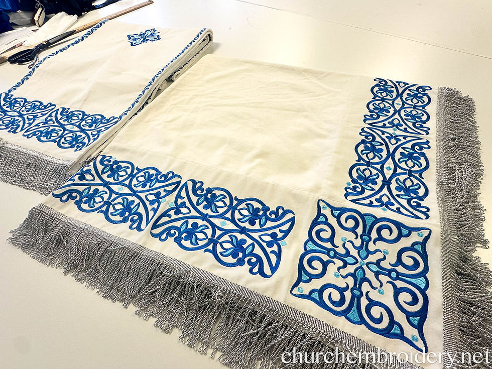 Set of blue-and-white embroidered Orthodox chalice covers laid on a table