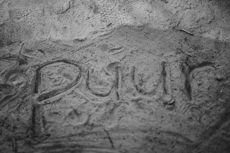 PUUR geschreven in het zand