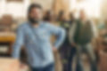 A smiling carpenter with his staff in the background.jpg