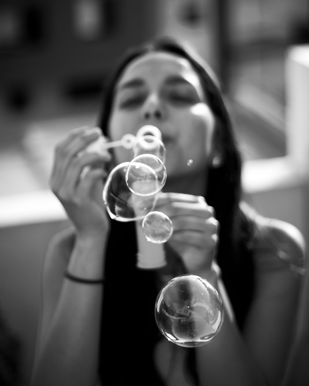 Black and White photo of girl blowing bubbles