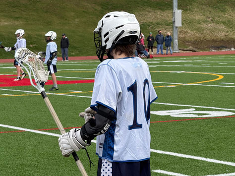 Owen Malouin on the sidelines during a lacrosse game at The Bement School, rear view.