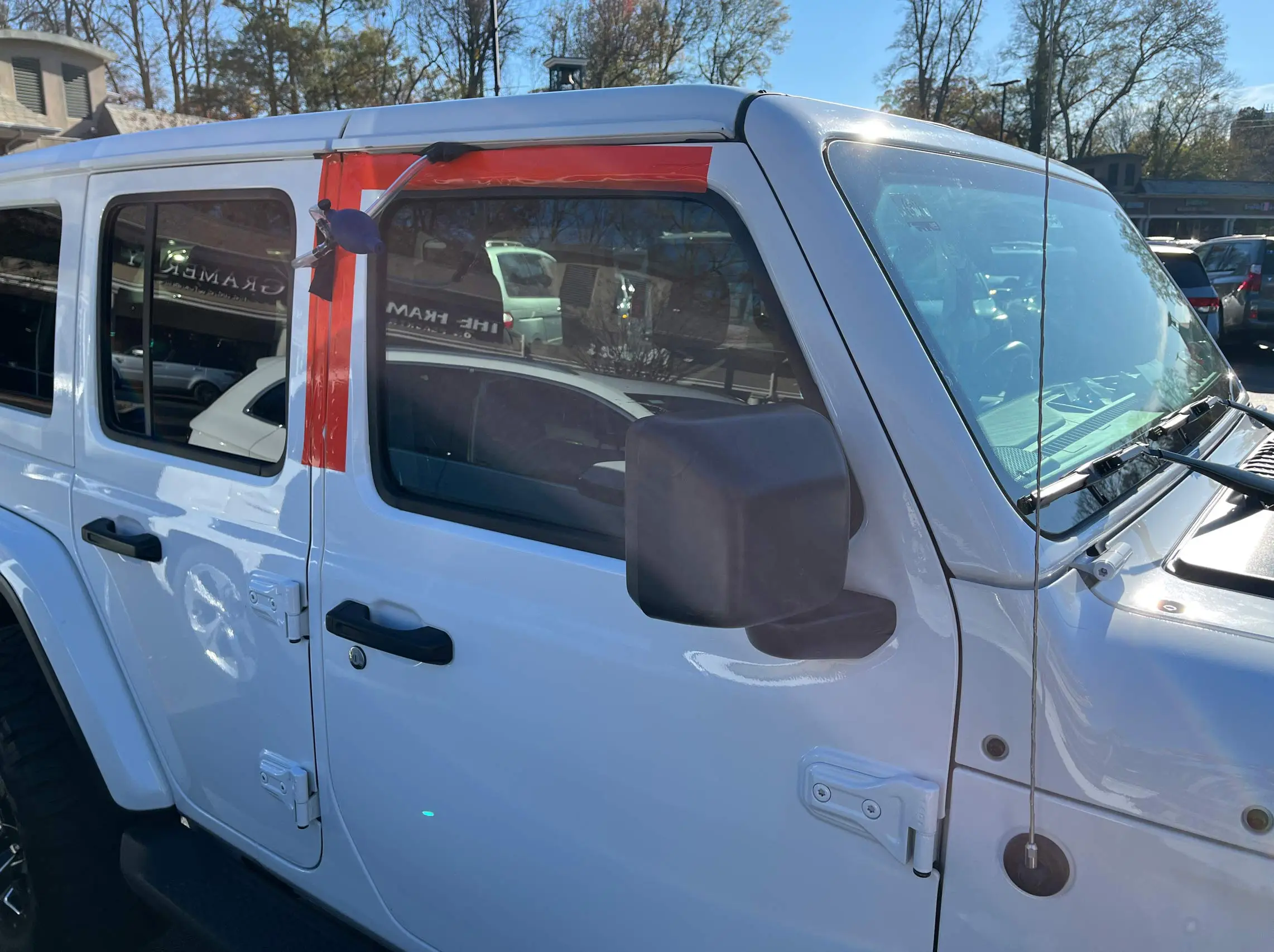 Protective tape on white Jeep with keys in car