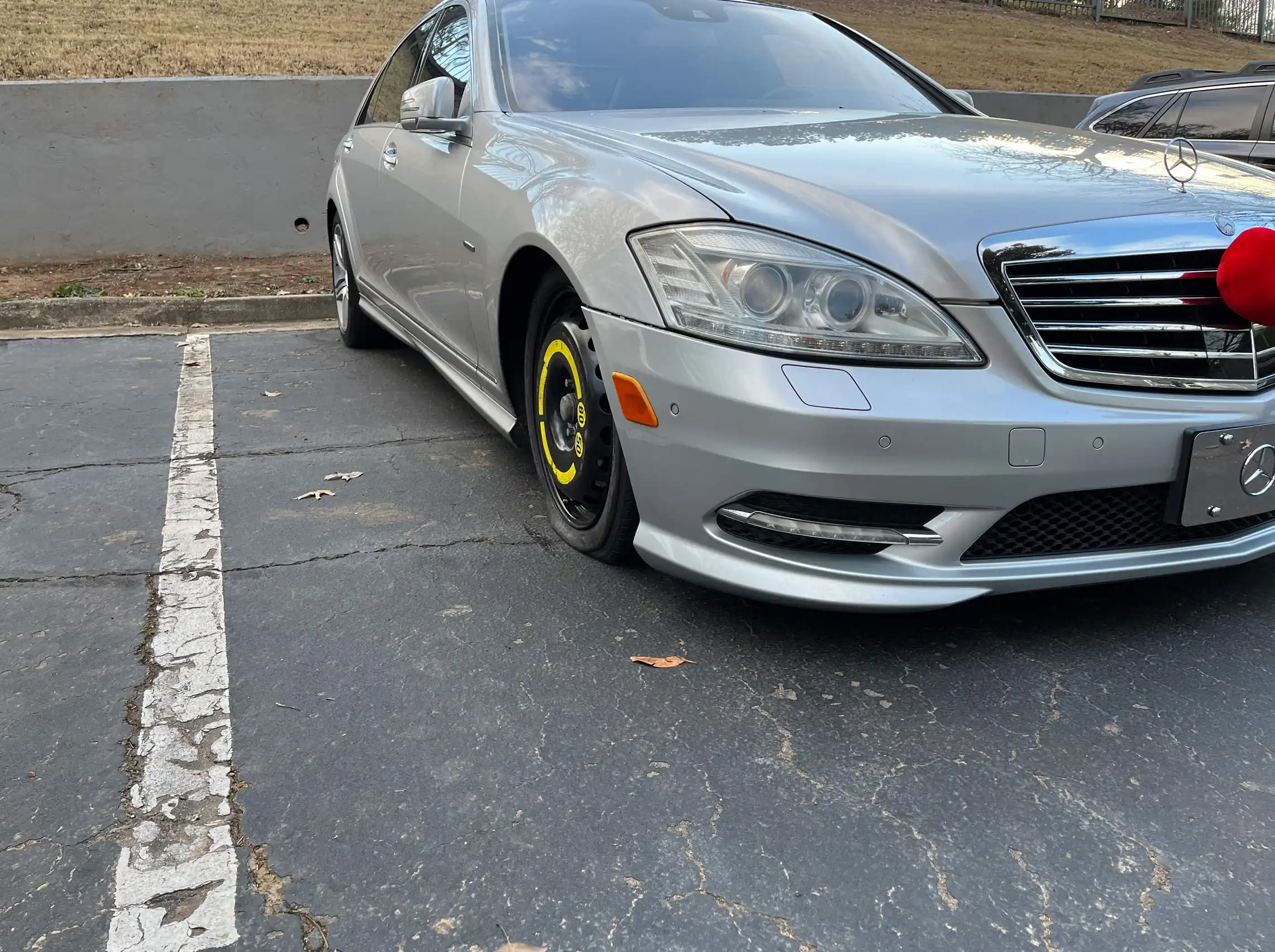 Mobile spare tire change service on a gray Mercedes