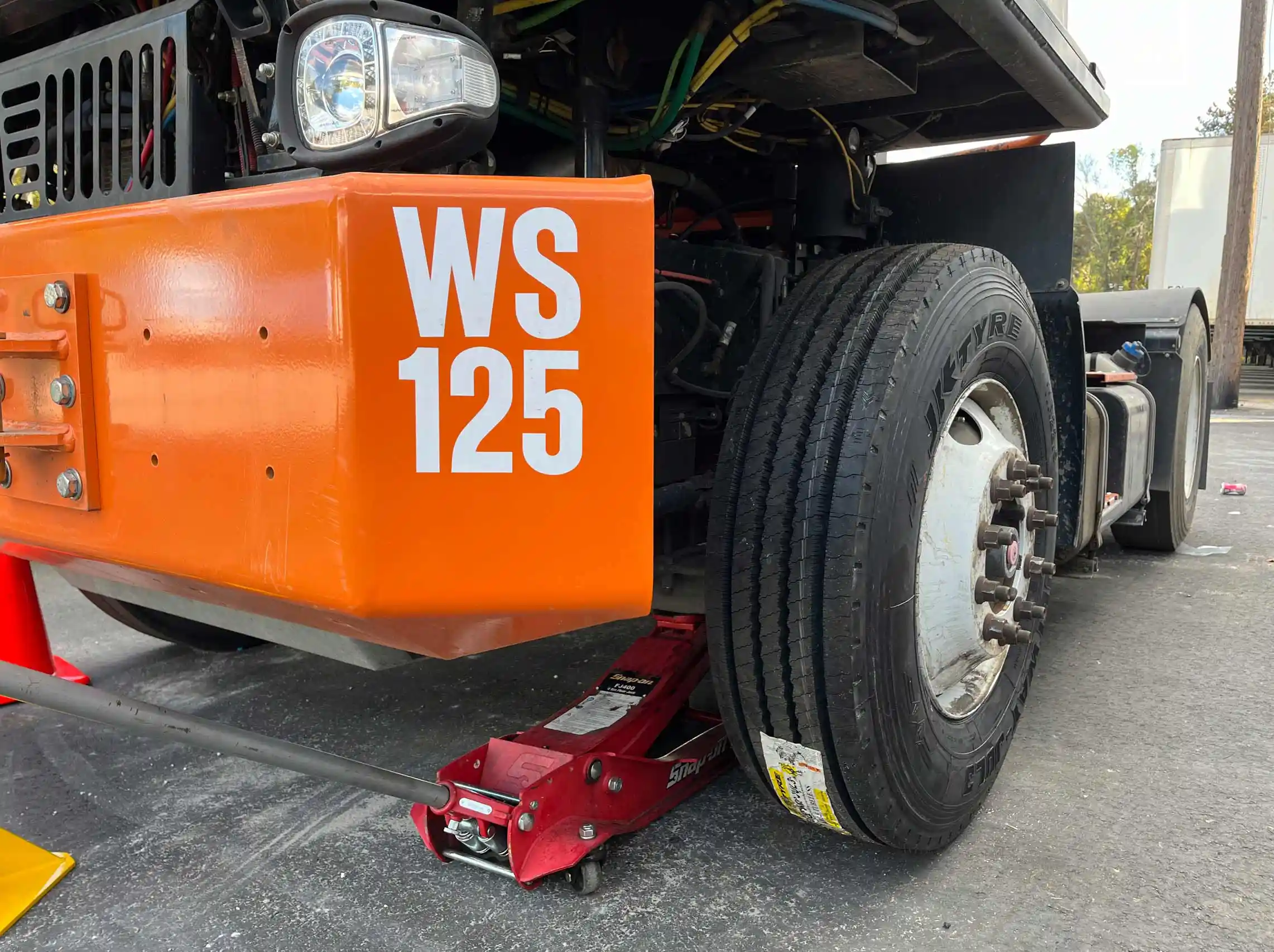 Mobile commercial tire replacement on semi truck with red jack