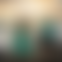 a vegan couple who are enjoying the beach with turquoise, mustard yellow and black colours in their outfits, they are joyful and the man is splashing water at his partner from the ocean and they are holding hands; the couple are compassionate, spiritual and they eat in alignment with those values