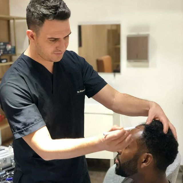 Doctor Kinyas Dusunmez drawing the hairline during a hair transplant consultation in Turke