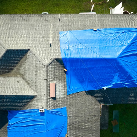 Blue tarp over a shingle roof to prevent water from leaking in before the roof is replaced.