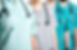 Doctors dressed in surgical suits stand
