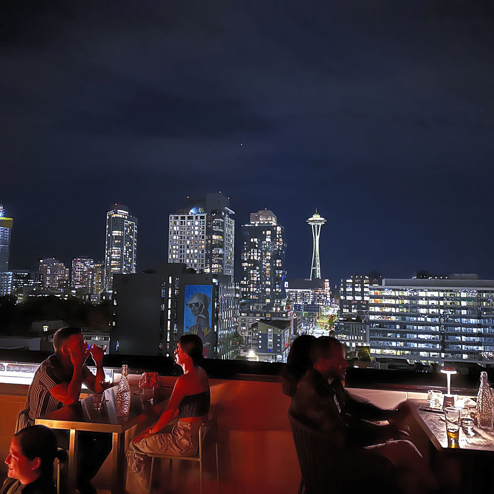 Panoramic view of the Seattle skyline as seen from Altitude Rooftop Bar, with a stunning sunset in the background.